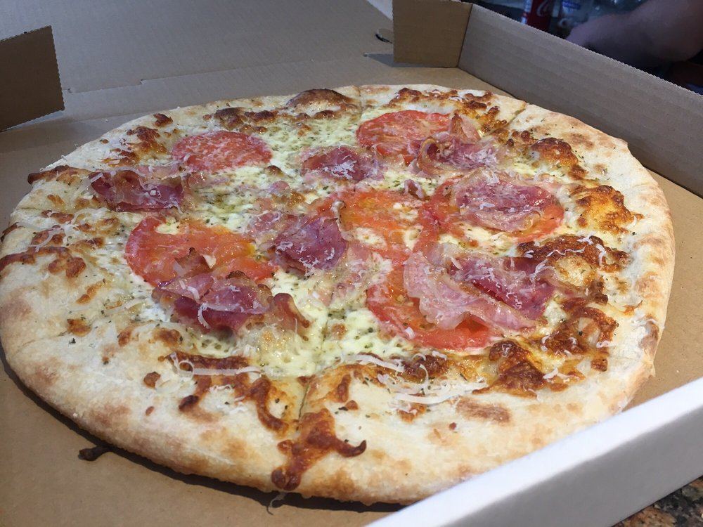 White pizza with cured meat and tomato